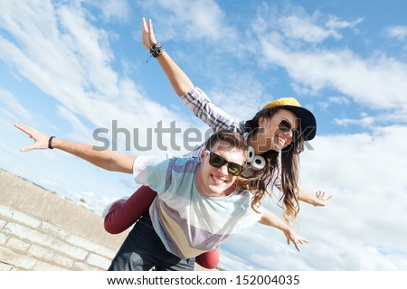 summer holidays and teenage concept - teenagers having fun outside