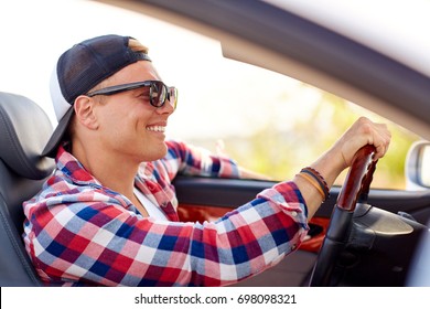 Summer Holidays, Travel, Road Trip And People Concept - Happy Smiling Young Man In Sunglasses And Cap Driving Convertible Car