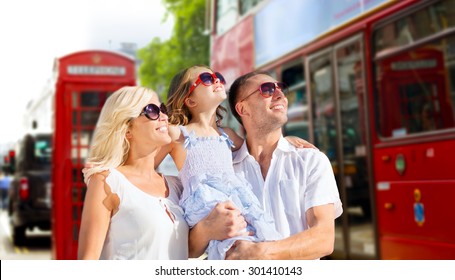Summer Holidays, Travel, Tourism And People Concept - Happy Family In Sunglasses Looking Up Over London City Street Background