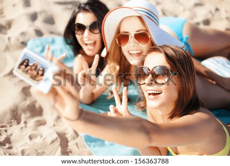 summer holidays, vacation and beach concept - girls taking selfie on the beach