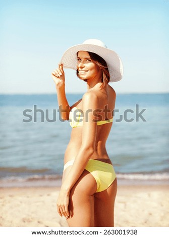 summer holidays and vacation concept - girl in bikini standing on the beach
