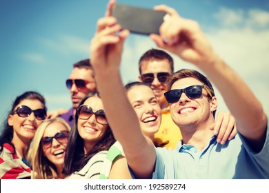 Summer, Holidays, Vacation And Happiness Concept - Group Of Friends Taking Selfie With Smartphone