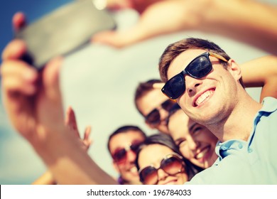 summer, holidays, vacation and happiness concept - group of friends taking selfie with smartphone - Powered by Shutterstock