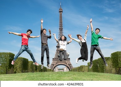 Summer, Holidays, Vacation, Happy People Concept - Group Of Friends Jumping On The Park Near Eiffel Tower In Paris, France