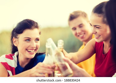 Summer Holidays, Vacation, People And Party Concept - Group Of Happy Friends Having Fun And Drinking Non-alcoholic Beer Or Soda Lemonade On Beach