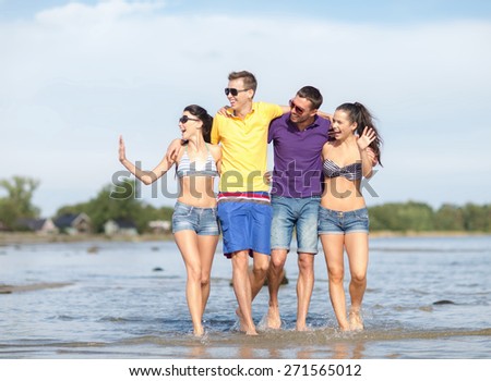 summer holidays, vacation, tourism, travel and people concept - group of happy friends walking and waving hands along beach