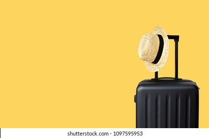 Summer holidays, vacation and travel concept. Suitcase or luggage bag with sun hat on yellow background for copy space.                                 