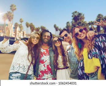 summer holidays, vacation, travel and people concept - smiling young hippie friends showing peace hand sign over venice beach in los angeles background - Powered by Shutterstock