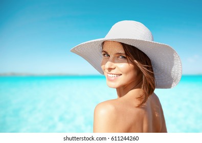 Summer Holidays, Vacation, Travel And People Concept - Smiling Young Woman In Sun Hat On Beach Over Sea And Blue Sky Background