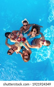 Sommerferien und Ferien,Freundesgruppe toast mit Cocktails im Pool.