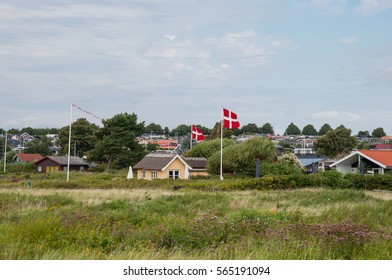 Summer homes and Danish flag in front of vacation homes in Karrebaeksminde in Denmark