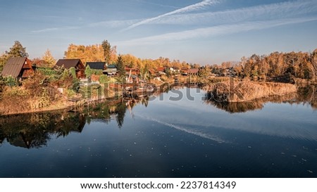 Summer houses on a lake formed after a former gravel mine in Silesia, Poland from a bird's eye view in autumn, Olza, Gorzyce commune
