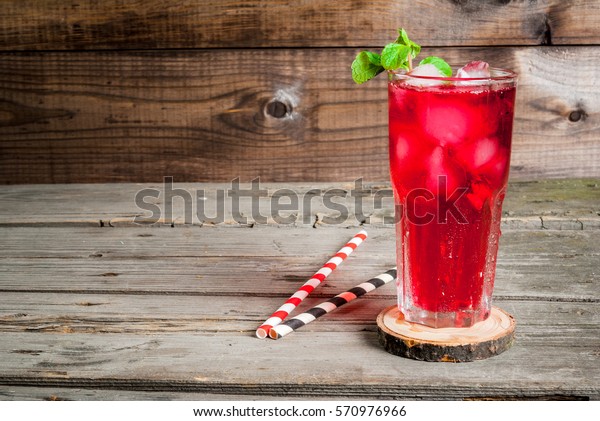Summer iced drink - tea or\
juice with ice and mint. On rustic wooden table, copy space,\
horizontal