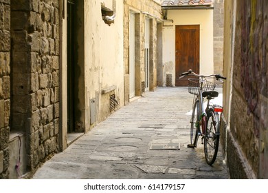 Summer. Italy. Florence. A bicycle with a basket on a narrow European street. Stone houses. Paving stone - Powered by Shutterstock