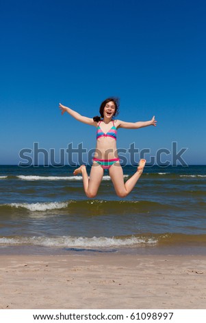 Summer joy - girl jumping on beach