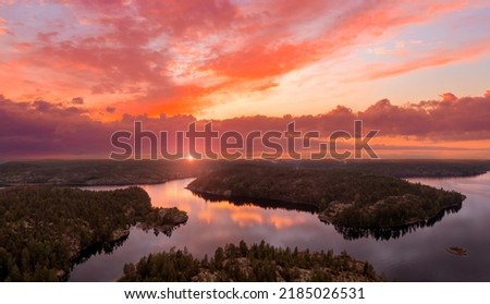 Summer Karelia. Russian landscape. Red sunset over Lake Ladoga. Nature of Russia. Beautiful pink sky over Karelia. Ladoga skerries and forests. Karelia tourism. Northern nature view from quadrocopter