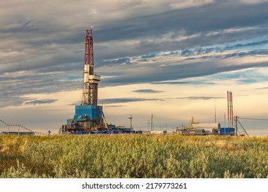 The Summer Landscape Of The Arctic Tundra Against The Background Of Infrastructure For Drilling Wells And Oil And Gas Production. In The Foreground Is The Vegetation Of The Northern Nature