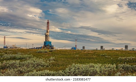 The Summer Landscape Of The Arctic Tundra Against The Background Of Infrastructure For Drilling Wells And Oil And Gas Production. In The Foreground Is The Vegetation Of The Northern Nature