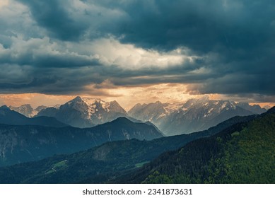 Summer landscape with dramatic dark cloudy sky over Triglav mountains range in Julian Alps - seasonal travel background