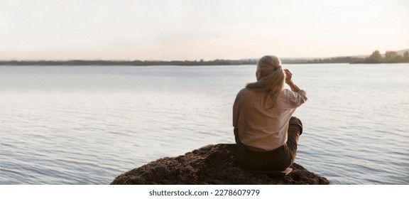 Summer lifestyle portrait senior woman with gray hair relaxes sitting on rocks on the seashore. Enjoying the little things. spends time in nature in summer.  meditation. - Powered by Shutterstock