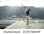 Summer love. Happy couple on dock. Man holding woman, she is enjoying freedom. Travel, love, fun, togetherness concept.