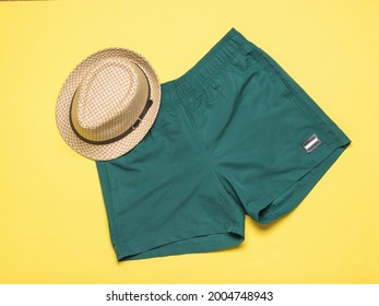 Summer Men's Hat And Green Shorts On A Yellow Background. Popular Summer Men's Accessories.