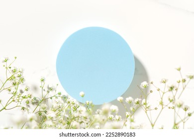 Summer minimal scene for beauty cosmetic product presentation made with blue circle geometric shape and wild flowers on white background. Top view. - Shutterstock ID 2252890183