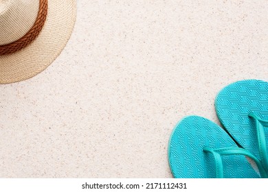 Summer minimalist mockup template on a sand background with straw hat, flipflop and sand. Tropical vacation concept.