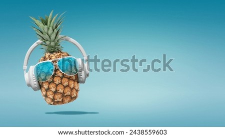 Summer minimalist pop art photography made with pineapple wearing headphones and listening to music.Minimal concept summer and party.Celebrating the summer vibes.Creative art.Contemporary style.