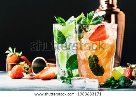 Summer Mojito cocktail or mocktail set with lime, mint, strawberry and ice in glass on black background. Cold alcoholic or non-alcoholic drinks, beverages and cocktails