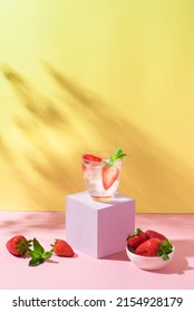 Summer mojito or fruit cocktail with strawberries on yellow and pink background. Strawberry Mojito. Refreshing summer drink with copy space, front view