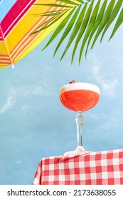 Summer Mood. Bottom View Of Cocktail Glass With Delicious Clover Club Over Blue Sky Background. Vacation, Happiness, Summer Vibes. Retro Style Photo. Tropical Climate