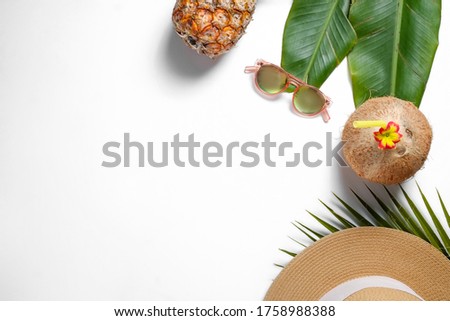 Summer mood concept. Tropical background with ripe organic pinapple, fresh whole coconut with cocktail straw sunglasses and different palm leaves. Flat lay, top view, close up copy space, isolated.