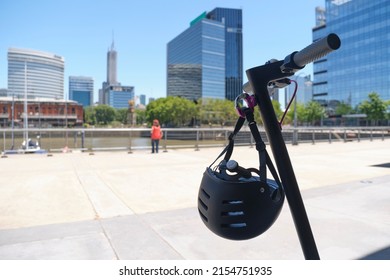 Summer Morning In Puerto Madero, Buenos Aires, Electric Scooter Standing Still, With A Sports Helmet. Concepts: Sustainable Urban Living, Road Safety.