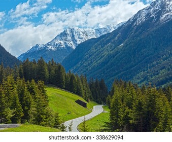 Summer mountain landscape with fir forest on slope and country road(Silvretta Alps, Austria).