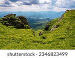 summer mountain landscape. rocks on the grassy hills. beautiful scenery on a sunny day
