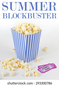 Summer Movie Theme With A Blue And White Striped Bucket Full Of Popcorn And Two Purple Movie Tickets. Popcorn Is Scattered About White Background. Removable Summer Blockbuster Movie Text