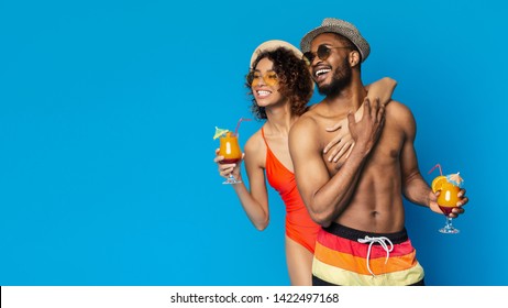 Summer offer. Cute african couple in swimwear embracing and looking at empty space, blue panorama background - Powered by Shutterstock