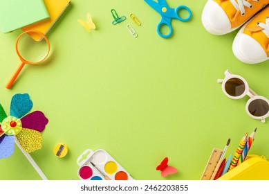 Summer outdoor learning theme. Overhead shot of art materials - crayons, watercolors, clips, scissors, books, shades, shoes, pinwheel, and butterflies on soft green backdrop. Space for text or promo - Powered by Shutterstock