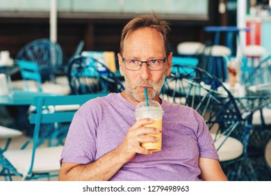 Summer outdoor portrait of happy man holding milkshake - Powered by Shutterstock