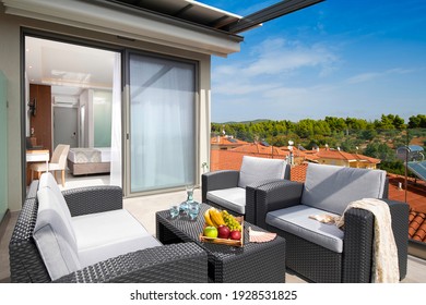 Summer panoramic view of roof top open terrace with wicker furniture in modern studio room apartment of European resort hotel