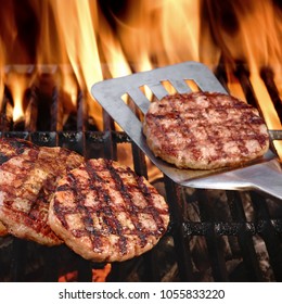 Summer Party Cookout Food. BBQ Grilled Burgers Or Patties On The Hot Flaming Charcoal Cast Iron Grill. Grilled Burger On The Barbecue Tool. Spatula With Barbeque Roasted Patty.