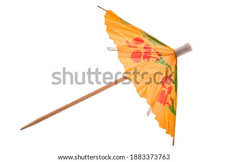 Summer party and drinking glass decoration concept with picture of colourful orange cocktail paper decorative umbrella isolated on white background with clipping path cutout