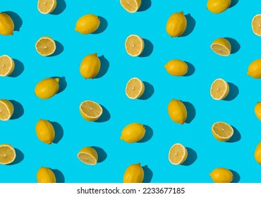 Summer pattern made with fresh cut and whole yellow lemon on bright light blue background. Minimal background summer concept on with harsh light and sharp shadow - Shutterstock ID 2233677185
