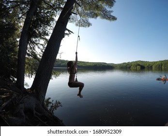 Summer Photo. Girl On A Rope Swing In New Hampshire. At A Lake.