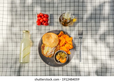 A Summer Picnic Atmosphere, Tablecloth On The Lawn With Plates Of Healthy Food And Fruit Drinks. Flat Lay Food. Olive Oil, Salads, Sandwich, Quinoa Salad, Vegan Burger