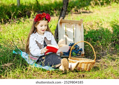 Summer - picnic . girl sitting reading a book and near a picnic basket and baguette, wine, glasses, grapes and rolls - Powered by Shutterstock