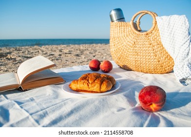 Summer picnic on the beach by the sea at a sunrise. Warm sunny morning.