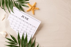 Summer Planning Time: Serene Setup With June Calendar, Starfish, And Green Foliage, Laid Out On A Sandy Background, Ideal For Vacation Planning Themes
