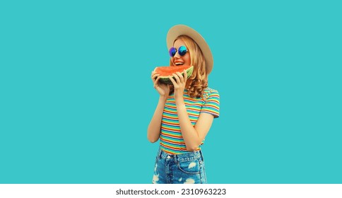 Summer portrait of happy smiling young woman with fresh juicy slice of watermelon wearing straw hat on blue background - Shutterstock ID 2310963223